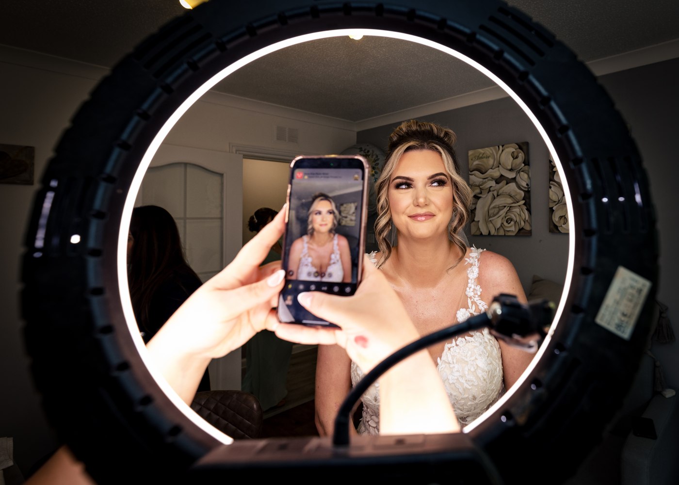 Bride glancing at a photo on her phone while getting ready