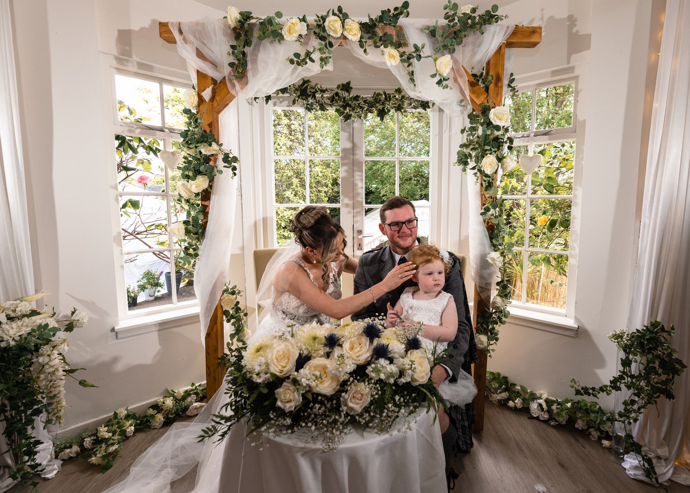 Bride and groom with their flower girl at the signing table