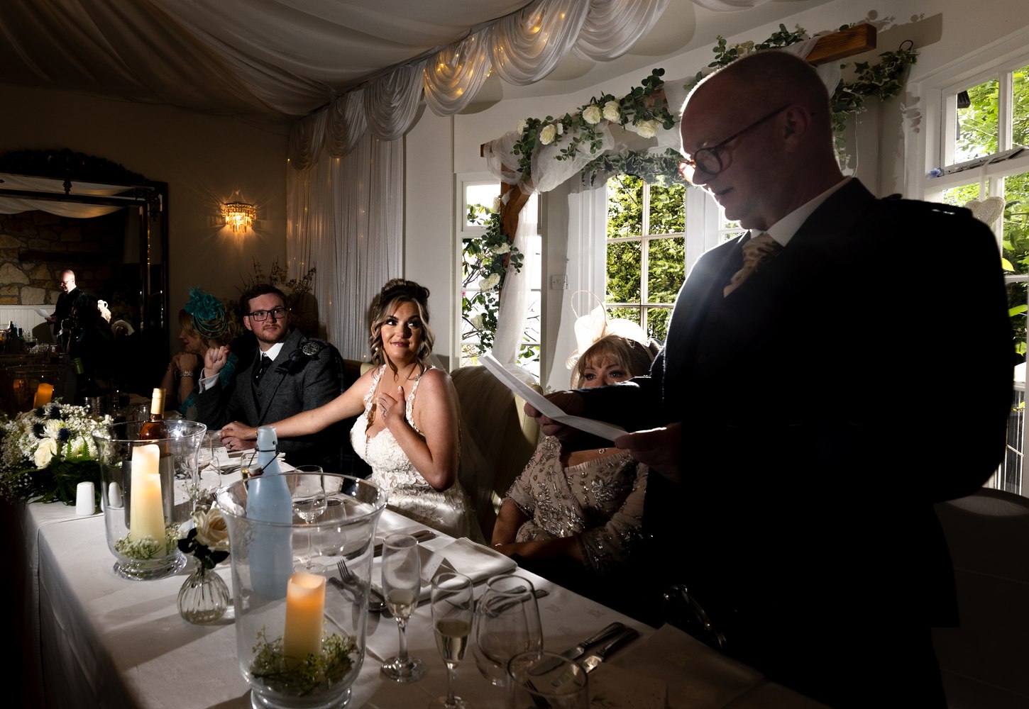 Groom giving his speech as the bride looks on, moved