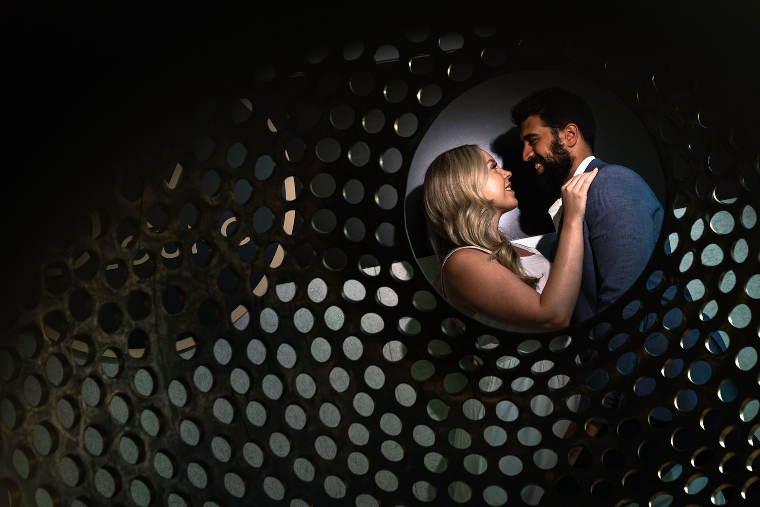 Couple framed through a perforated metal screen