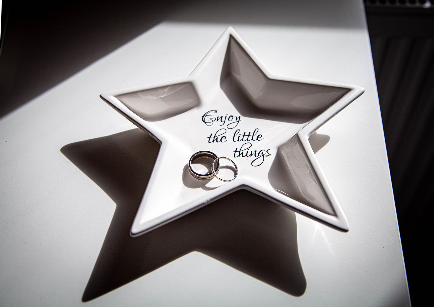 Wedding rings resting on a star-shaped dish reading
