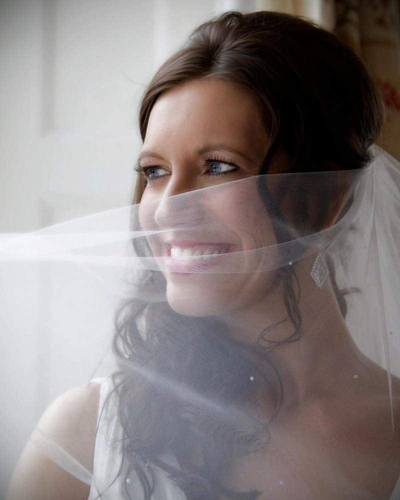 Bride smiling behind her veil