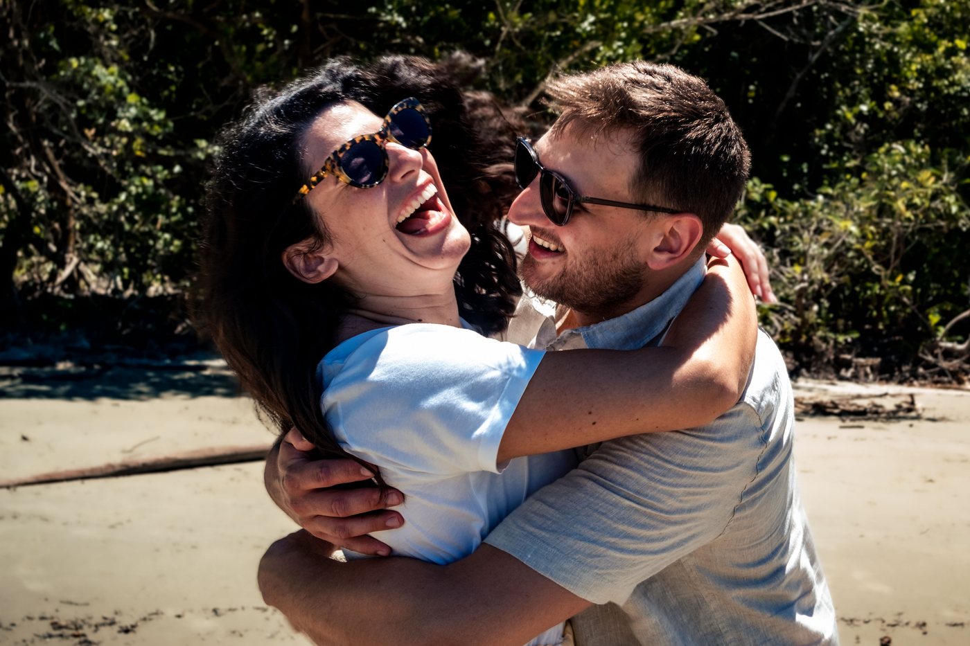 Marianna laughing in Lukas's arms on the beach
