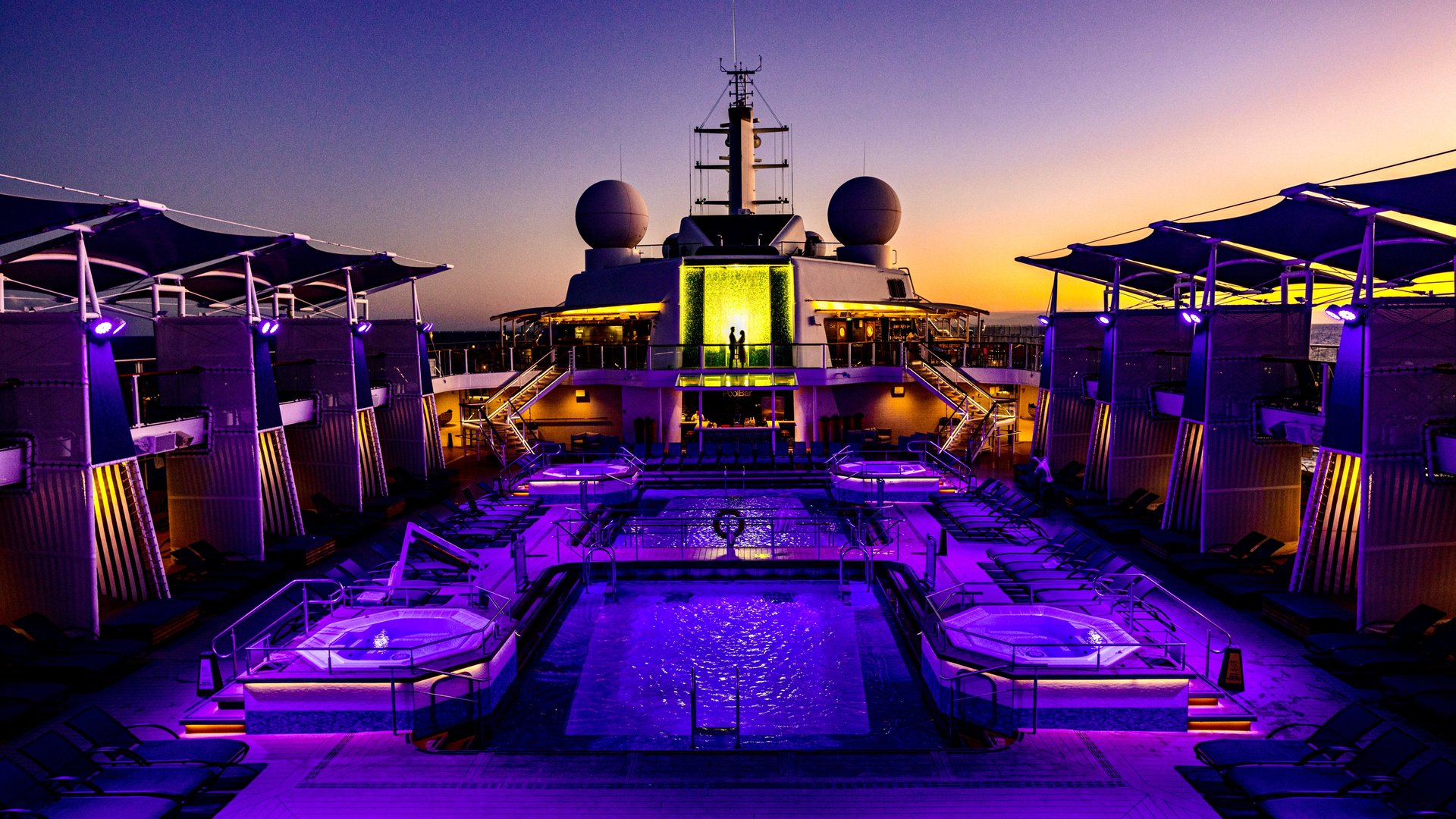 Couple sharing a quiet moment during their destination wedding reception aboard a cruise ship at dusk