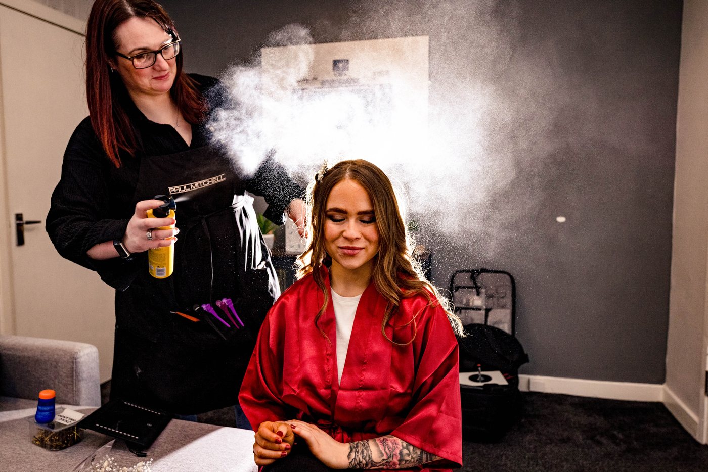 A cloud of hairspray catching the light during bridal prep