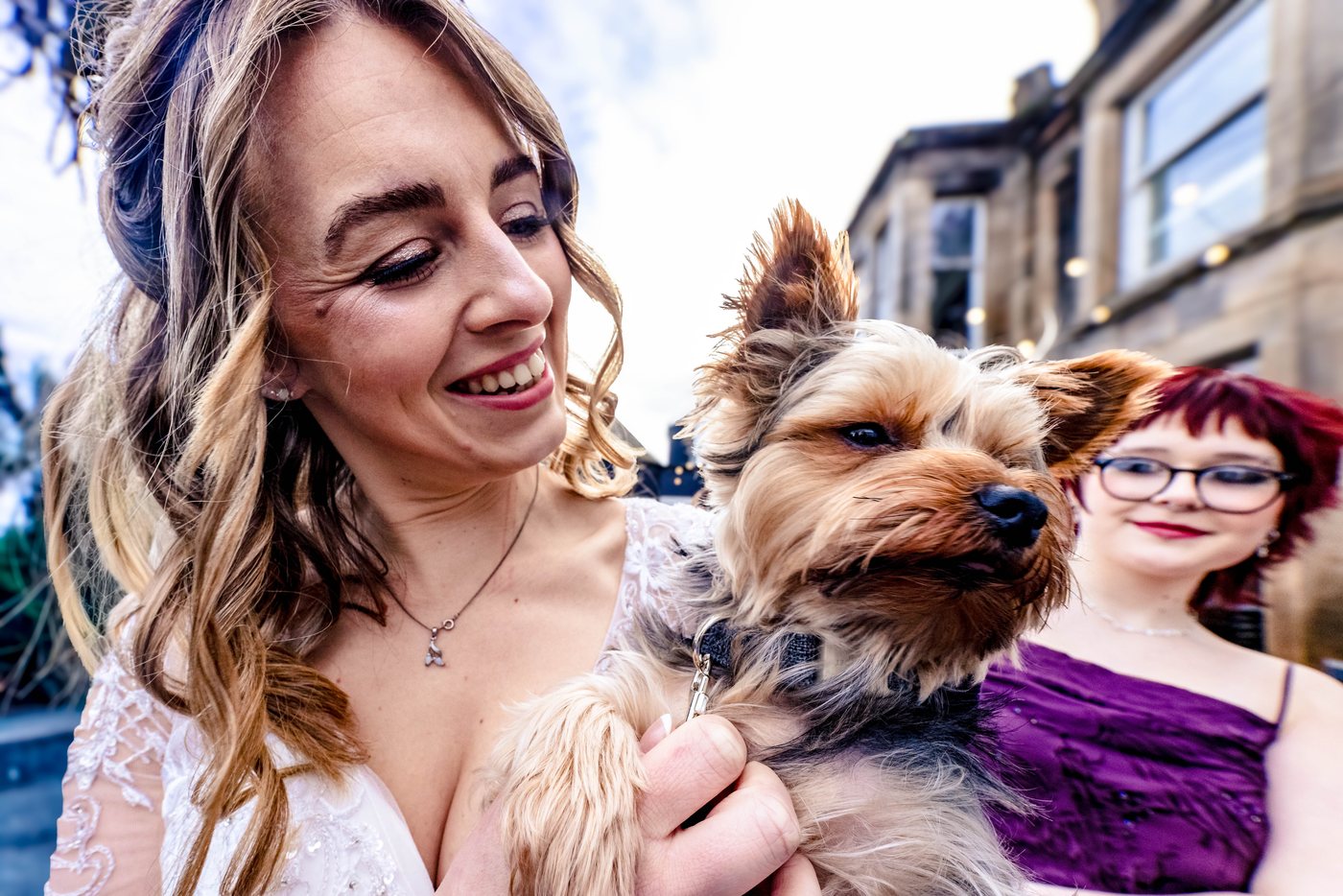 The bride laughing with the family dog before the ceremony