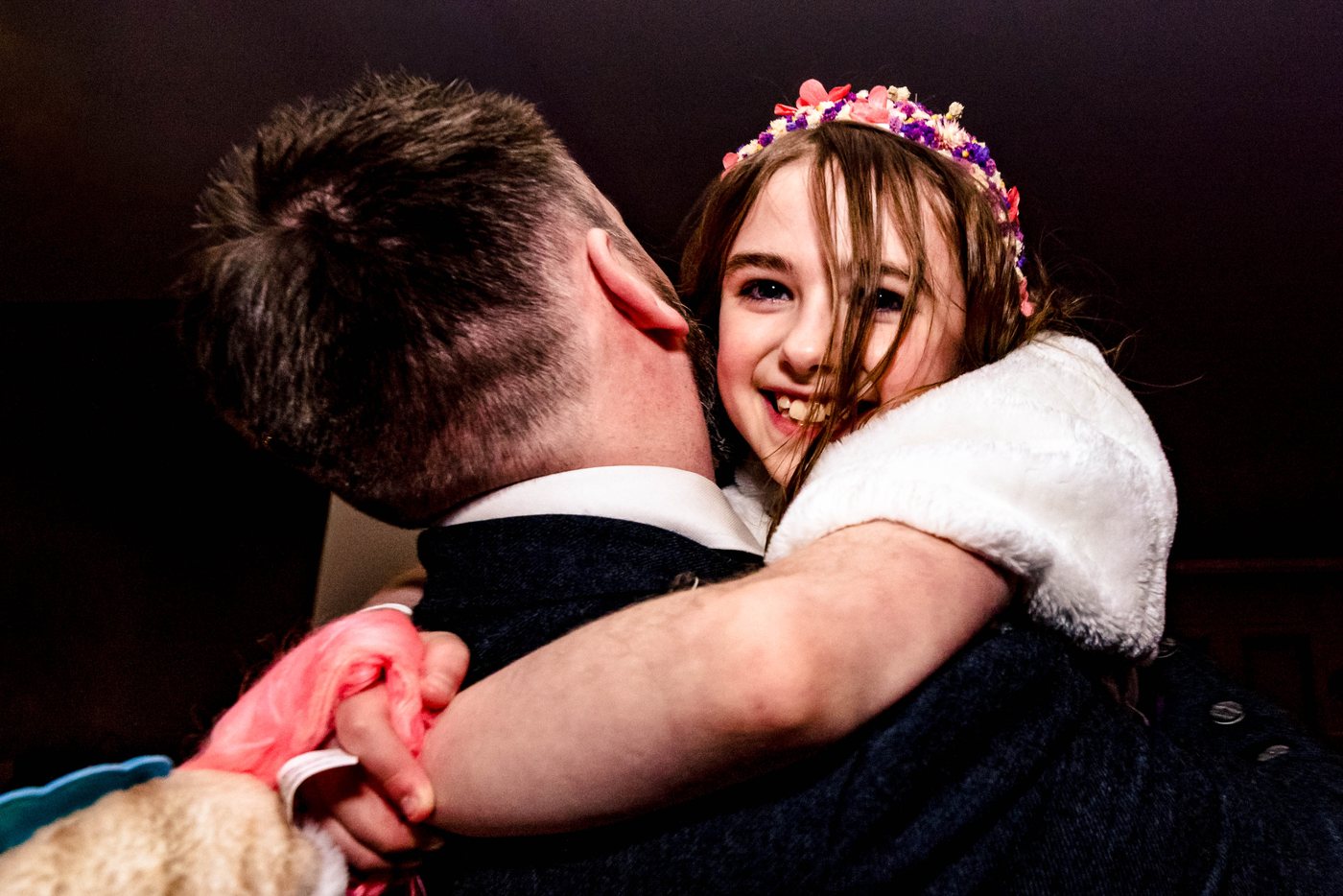 A guest hugging a young flower girl during the reception