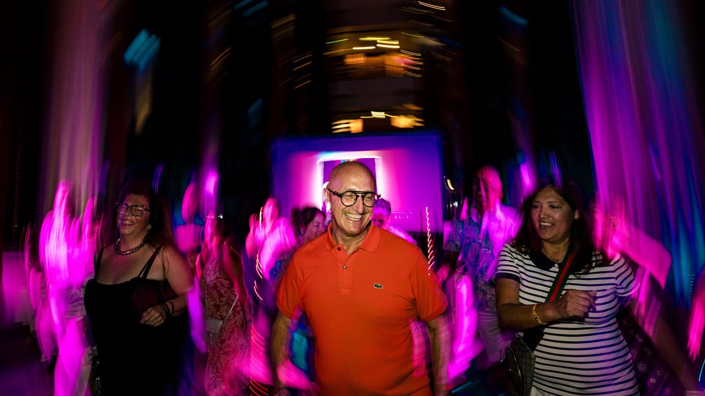 A guest dancing in the middle of the floor as the room blurs around him